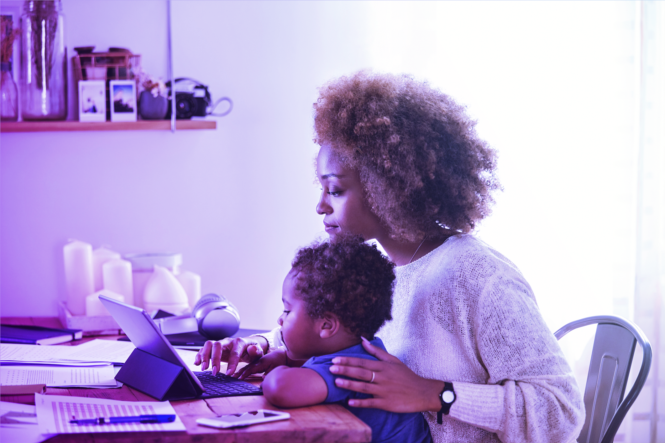 woman working from home with child on her lap