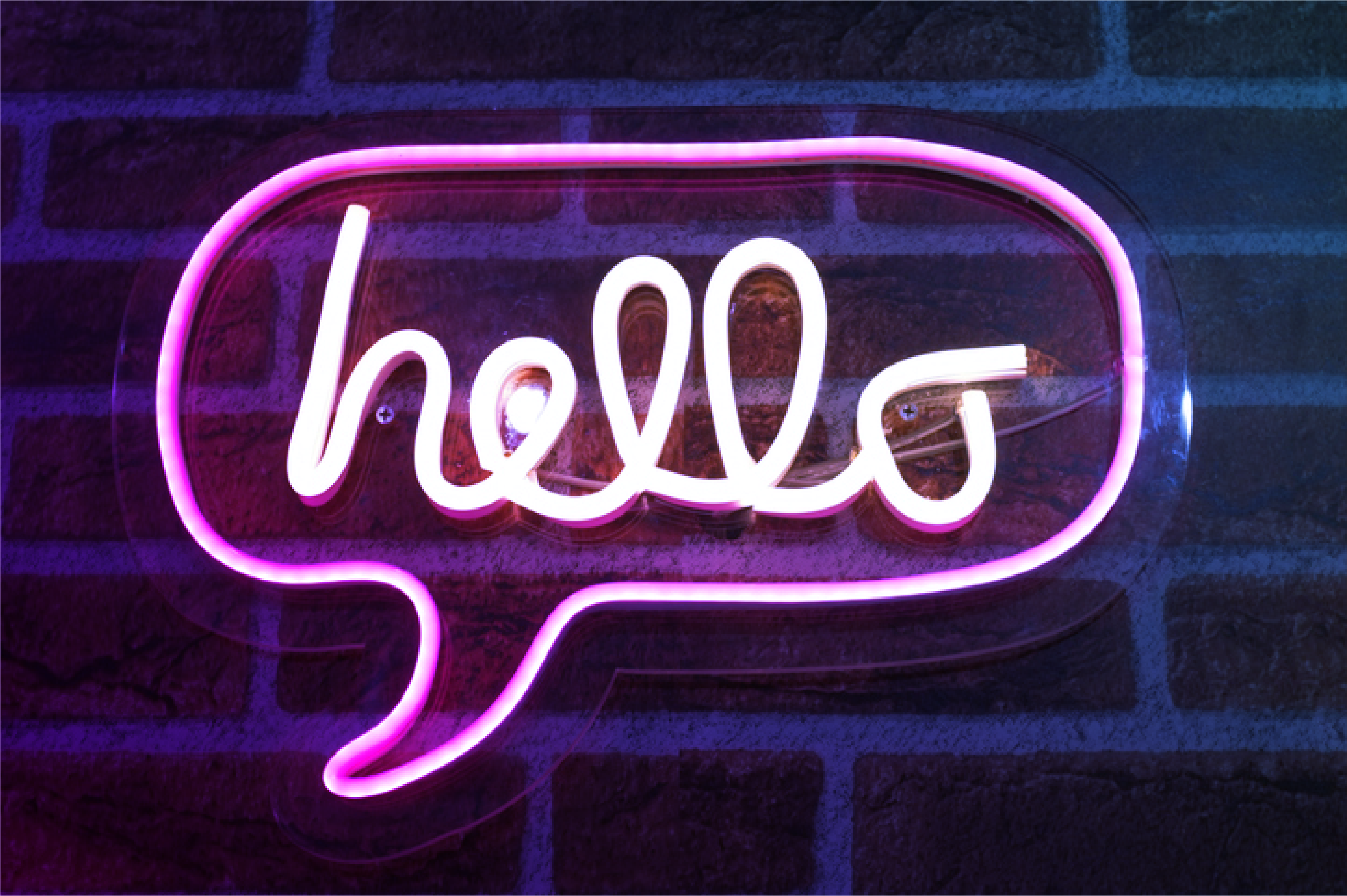 Image of a neon sign, consisting of a a thought bubble saying hello in script 