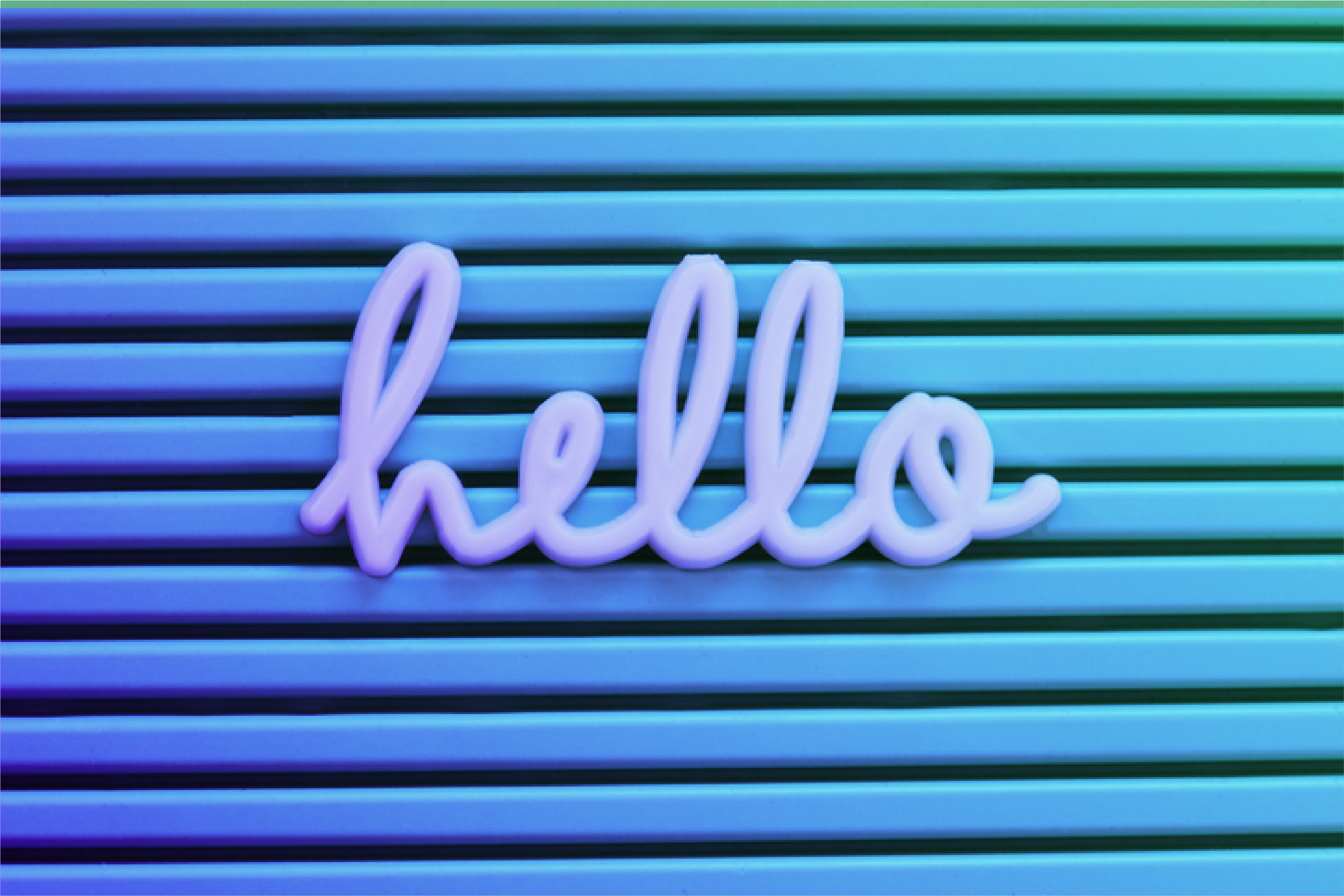 "Hello" written in lowercase scripted against a green and blue background